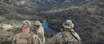 Movie still from “Cartel Land” (2015), directed by Matthew Heineman – A group of men standing on top of a hill; Extreme Wide shot, Over the shoulder angle