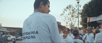 Movie still from “Cartel Land” (2015), directed by Matthew Heineman – A group of men standing next to each other on top of a field; Medium shot, Low angle
