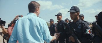 Movie still from “Cartel Land” (2015), directed by Matthew Heineman – A group of men in police uniforms shaking hands; Medium shot, Over the shoulder angle