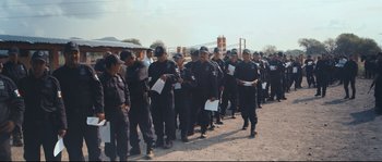 Movie still from “Cartel Land” (2015), directed by Matthew Heineman – A large group of men in black suits and hats; Wide shot, High angle