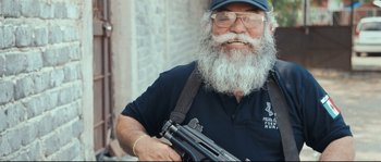 Movie still from “Cartel Land” (2015), directed by Matthew Heineman – An old man with a beard holding a gun; Medium shot, Low angle