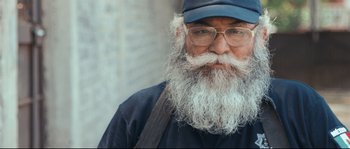 Movie still from “Cartel Land” (2015), directed by Matthew Heineman – An old man with a long beard wearing glasses and a hat; Close Up shot, Low angle