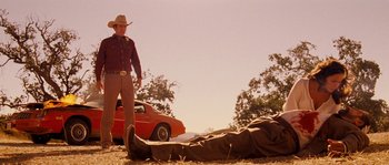 Movie still from “Casa de mi Padre” (2012), directed by Matt Piedmont – A man standing next to a dead body on the ground; Wide shot, Low angle