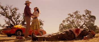 Movie still from “Casa de mi Padre” (2012), directed by Matt Piedmont – A man and a woman standing next to an old car; Wide shot, Low angle