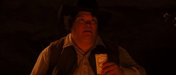 Movie still from “Casa de mi Padre” (2012), directed by Matt Piedmont – A man in a cowboy hat holding a box of cigarettes; Close Up shot, High angle