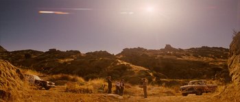 Movie still from “Casa de mi Padre” (2012), directed by Matt Piedmont – A group of people standing on top of a dry grass field; Extreme Wide shot, Low angle