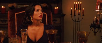 Movie still from “Casa de mi Padre” (2012), directed by Matt Piedmont – A woman sitting in front of a wine glass in front of candles; Close Up shot, Over the shoulder angle