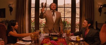 Movie still from “Casa de mi Padre” (2012), directed by Matt Piedmont – A man holding a wine goblet in front of a window; Medium shot, Low angle
