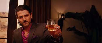 Movie still from “Casa de mi Padre” (2012), directed by Matt Piedmont – A man holding a glass of whiskey and a cigarette; Close Up shot, Low angle