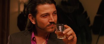 Movie still from “Casa de mi Padre” (2012), directed by Matt Piedmont – A person holding a glass of beer; Close Up shot, Over the shoulder angle