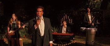 Movie still from “Casa de mi Padre” (2012), directed by Matt Piedmont – A man in a suit and tie holding a microphone and another man in a suit and tie holding a microphone; Medium shot, High angle