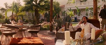 Movie still from “Casa de mi Padre” (2012), directed by Matt Piedmont – An outdoor living area with a couch , chairs , table and a fire pit; Wide shot, High angle