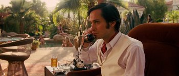 Movie still from “Casa de mi Padre” (2012), directed by Matt Piedmont – A man sitting at a table talking on a phone; Medium shot, Over the shoulder angle