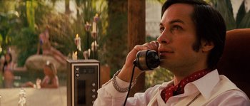 Movie still from “Casa de mi Padre” (2012), directed by Matt Piedmont – A man talking on a phone while sitting in front of candles; Close Up shot, Over the shoulder angle