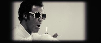 Movie still from “Casa de mi Padre” (2012), directed by Matt Piedmont – A man in sunglasses holding a lit candle; Extreme Close Up shot, Low angle