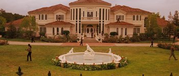Movie still from “Casa de mi Padre” (2012), directed by Matt Piedmont – A fountain in the middle of a lawn in front of a house; Extreme Wide shot, High angle