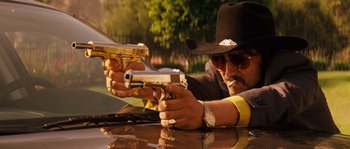 Movie still from “Casa de mi Padre” (2012), directed by Matt Piedmont – A man in a cowboy hat holding two guns; Close Up shot, Low angle