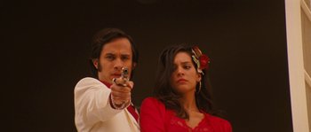 Movie still from “Casa de mi Padre” (2012), directed by Matt Piedmont – A man and a woman holding a gun in their hands; Close Up shot, Low angle