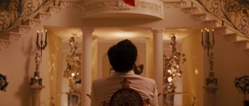 Movie still from “Casa de mi Padre” (2012), directed by Matt Piedmont – A man in a white jacket sitting in front of a mirror; Medium shot, Low angle