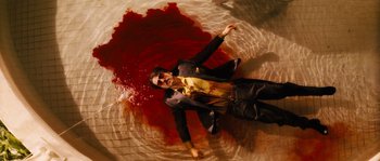 Movie still from “Casa de mi Padre” (2012), directed by Matt Piedmont – A man in a suit and tie laying in a pool of blood; Wide shot, Overhead angle