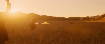 Movie still from “Casa de mi Padre” (2012), directed by Matt Piedmont – A person riding a horse through a field at sunset; Extreme Wide shot, Low angle