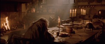 Movie still from “Casanova” (2005), directed by Lasse Hallström – A person sitting at a table with candles; Wide shot, High angle