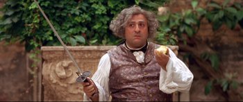 Movie still from “Casanova” (2005), directed by Lasse Hallström – A man with a knife and an apple in his hand; Medium shot, Over the shoulder angle