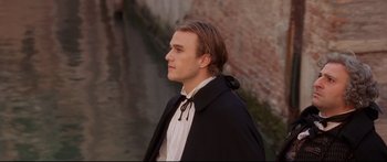 Movie still from “Casanova” (2005), directed by Lasse Hallström – A man in a black coat standing in front of a brick wall; Medium shot, Over the shoulder angle