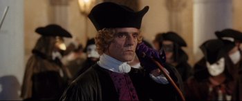 Movie still from “Casanova” (2005), directed by Lasse Hallström – A man dressed as a priest holding a staff in his hand; Medium shot, Over the shoulder angle