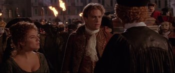 Movie still from “Casanova” (2005), directed by Lasse Hallström – A young man in a medieval costume walking through a crowd of people; Medium shot, Over the shoulder angle