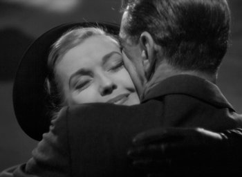Movie still from “Casanova Brown” (1944), directed by Sam Wood – An older man kissing a younger woman on the cheek; Close Up shot, High angle