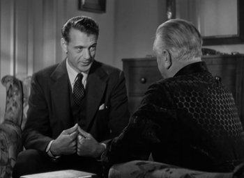 Movie still from “Casanova Brown” (1944), directed by Sam Wood – A man in a suit and tie shaking hands with another man in a suit and tie; Medium shot, Over the shoulder angle