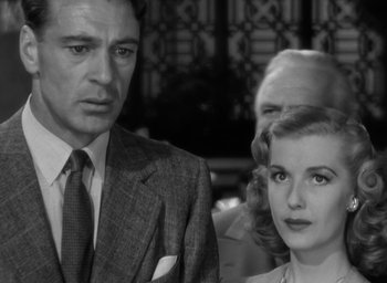 Movie still from “Casanova Brown” (1944), directed by Sam Wood – A man and a woman standing next to each other in front of another man; Close Up shot, Low angle