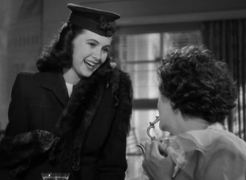 Movie still from “Casanova Brown” (1944), directed by Sam Wood – A woman wearing a hat and a fur coat talking to another woman in a suit; Medium shot, Over the shoulder angle