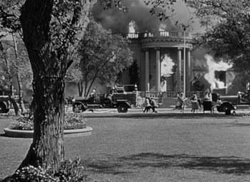 Movie still from “Casanova Brown” (1944), directed by Sam Wood – An old photo of a building on fire; Extreme Wide shot, Low angle