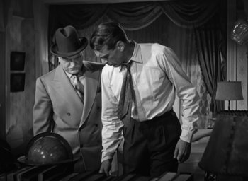Movie still from “Casanova Brown” (1944), directed by Sam Wood – Two men in suits and ties looking at a globe; Medium shot, Low angle