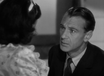 Movie still from “Casanova Brown” (1944), directed by Sam Wood – A man in a suit and tie talking to a woman in a white dress; Close Up shot, Over the shoulder angle