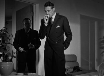 Movie still from “Casanova Brown” (1944), directed by Sam Wood – A man in a suit and tie standing in front of a mirror; Medium shot, Low angle