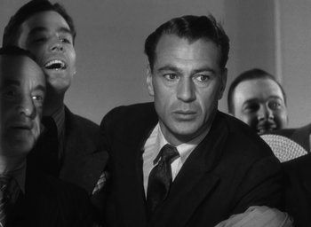 Movie still from “Casanova Brown” (1944), directed by Sam Wood – Black and white photograph of a man in a suit and tie; Close Up shot, Low angle