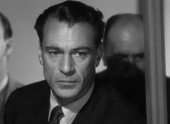 Movie still from “Casanova Brown” (1944), directed by Sam Wood – Black and white photograph of a man in a suit and tie; Close Up shot, Over the shoulder angle