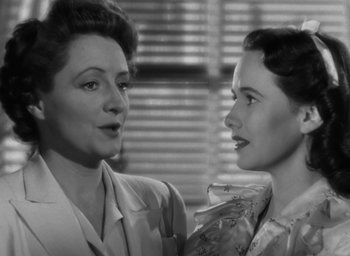 Movie still from “Casanova Brown” (1944), directed by Sam Wood – Two women standing next to each other in front of a window; Close Up shot, Low angle