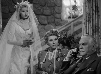 Movie still from “Casanova Brown” (1944), directed by Sam Wood – An old black and white photo of two women and an older man; Medium shot, Low angle