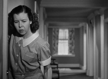 Movie still from “Casanova Brown” (1944), directed by Sam Wood – A woman standing in a room with a window in the background; Medium shot, Low angle