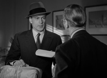 Movie still from “Casanova Brown” (1944), directed by Sam Wood – A man in a suit and a hat talking to another man in a suit; Medium shot, Over the shoulder angle