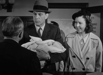 Movie still from “Casanova Brown” (1944), directed by Sam Wood – A man and a woman are holding a baby; Medium shot, Over the shoulder angle