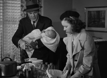 Movie still from “Casanova Brown” (1944), directed by Sam Wood – An old black and white photo of a man holding a baby; Medium shot, Low angle