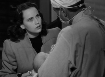 Movie still from “Casanova Brown” (1944), directed by Sam Wood – An old photo of a woman and a man holding a baby; Close Up shot, Over the shoulder angle