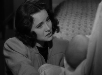 Movie still from “Casanova Brown” (1944), directed by Sam Wood – A woman sitting on a bed holding a baby; Close Up shot, High angle