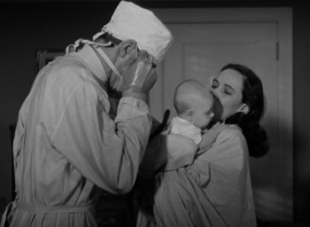 Movie still from “Casanova Brown” (1944), directed by Sam Wood – An old photo of a woman holding a baby and a doctor; Medium shot, Low angle