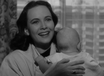 Movie still from “Casanova Brown” (1944), directed by Sam Wood – A woman holding a baby in her arms and smiling; Close Up shot, Low angle
